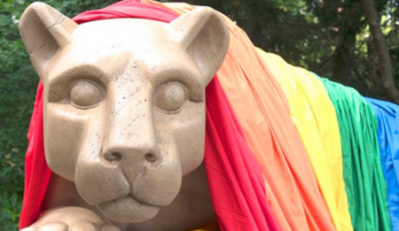 Nittany Lion statue with rainbow pride flag draped on it.