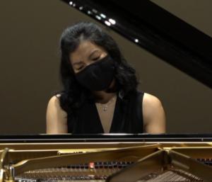 woman playing piano with mask on 