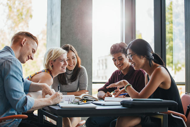 4 people sitting around a table talking