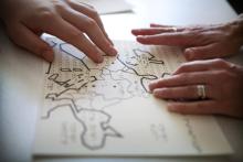 hands touching a braille map