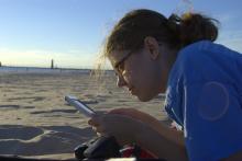 Person reading phone on the beach